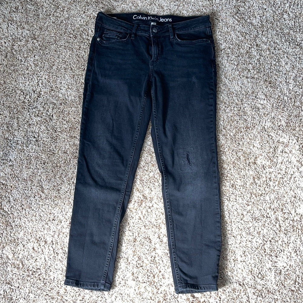 Black Calvin Klein jeans with small detail rip!